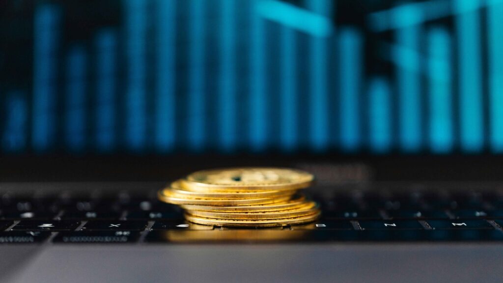 Stack of coins with data chart in background, representing digital revenue and game monetization strategy
