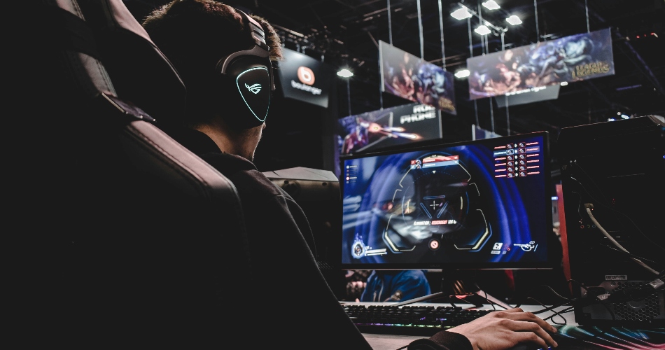 Developer creating an online video game at a gaming PC setup, showcasing modern html5 game engine technology and professional html5 game development environment with dual monitors and esports atmosphere.