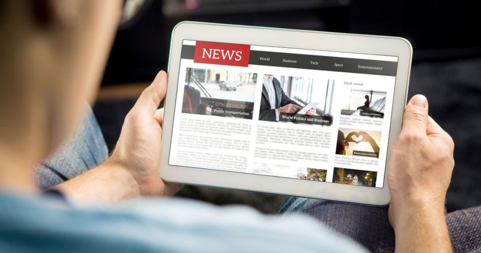 A businessman gesturing toward a tablet displaying a news website, illustrating the concept of white label gaming for media outlets.